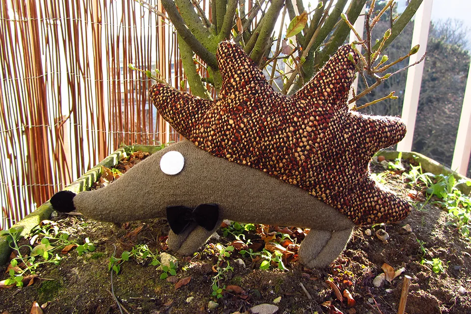 Le Hérisson aux piquants de tweed, nœud noir, dans un jardin.